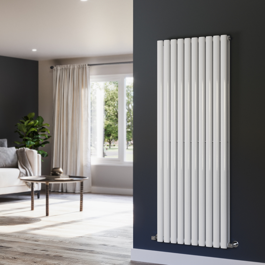 White vertical radiator on a dark gray wall with a living room in the background