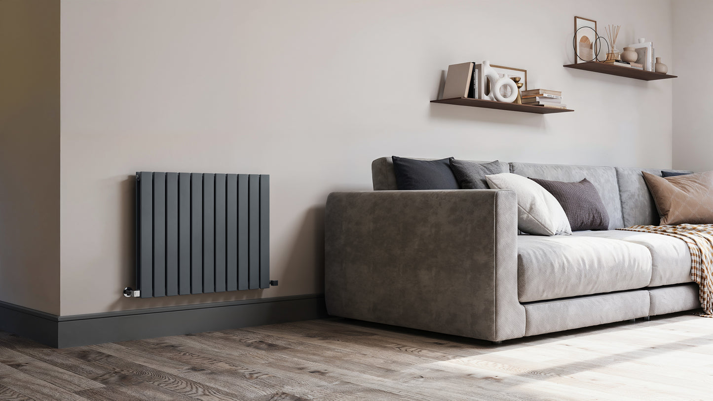 Modern living room with a gray sofa, wooden floor, and wall-mounted radiator.