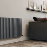 Modern radiator on a wall next to a gray sofa in a living room setting.