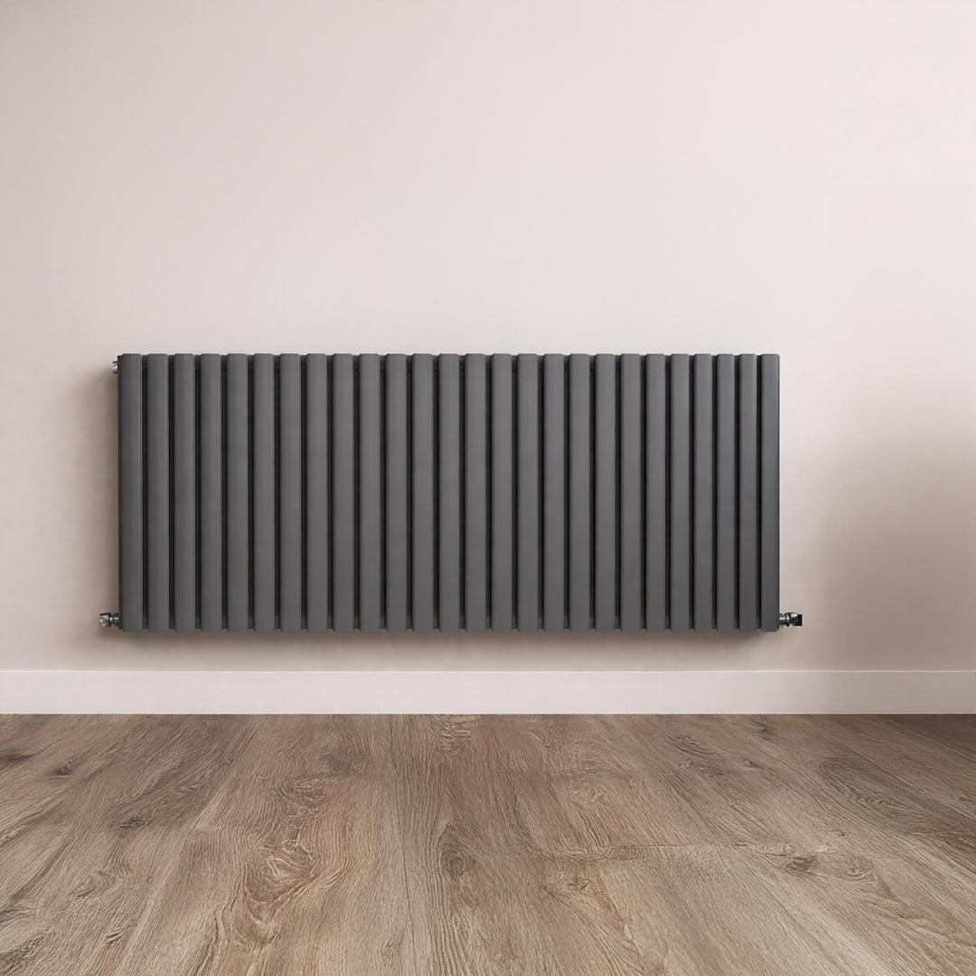Black radiator on a white wall with wooden flooring
