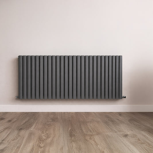Black radiator on a white wall with wooden flooring