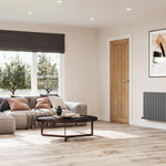Modern living room DOUBLE_OVAL radiator with a gray sofa, coffee table, and decorative wall art.