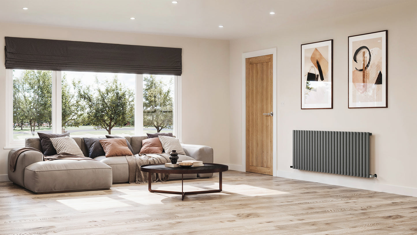 Modern living room DOUBLE_OVAL radiator with a gray sofa, coffee table, and decorative wall art.
