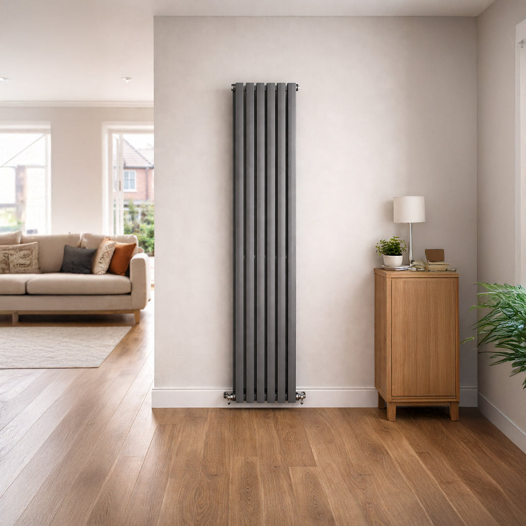 Tall vertical radiator in a living room with wooden floor and light-colored walls.