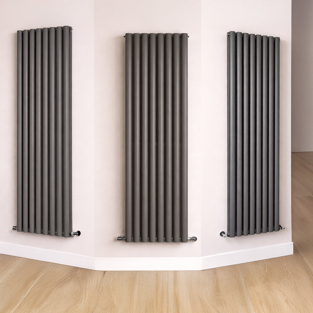 Three vertical radiators on a white wall with a wooden floor.