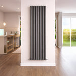 Vertical radiator on a white wall in a room with wooden flooring and a window.