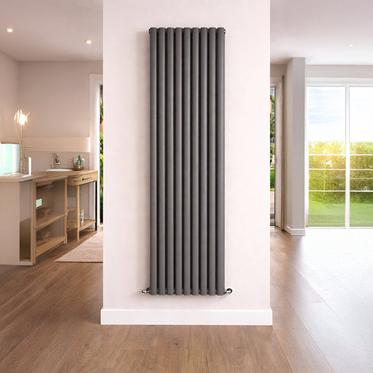Vertical radiator on a white wall in a room with wooden flooring and a window.