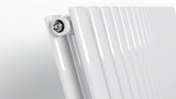 Close-up of oval tube detail on white vertical radiator